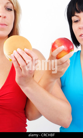 Due donne mangiare hamburger e Apple Foto Stock
