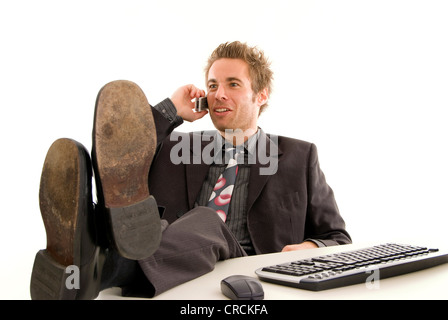 Uomo d'affari presso l'ufficio, telefona con il suo cellulare Foto Stock