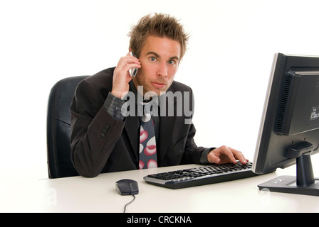 Giovane imprenditore nel suo ufficio, con il suo cellulare Foto Stock