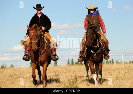 Cowboy e cowgirl cavalcare attraverso la prairie, Saskatchewan, Canada, America del Nord Foto Stock