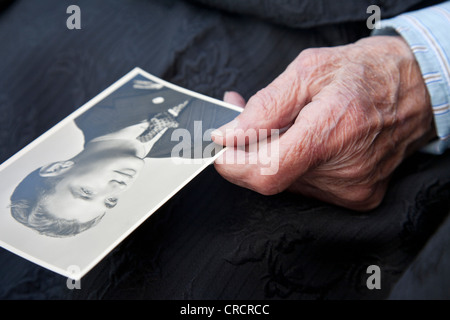 Visualizzazione di una foto vecchia, old man mano in possesso di una fotografia in bianco e nero, memorie, foto storiche, ritratto, casa di cura Foto Stock