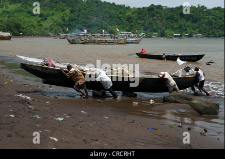 I pescatori tirando una barca a terra, Limbe, Camerun, Africa Foto Stock