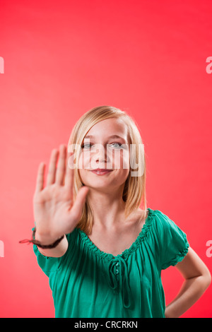 Ragazza adolescente alzando la mano per la difesa Foto Stock