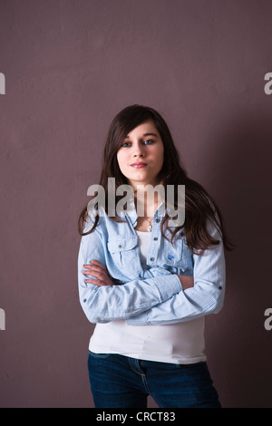 Fiducioso ragazza adolescente con bracci ripiegati Foto Stock