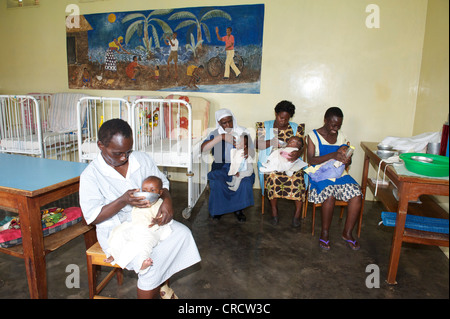 I neonati alimentati da bambini le infermiere in un orfanotrofio vicino a Bukoba, Tanzania Africa Foto Stock