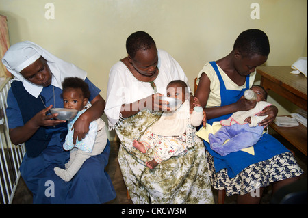 I neonati alimentati da bambini le infermiere in un orfanotrofio vicino a Bukoba, Tanzania Africa Foto Stock