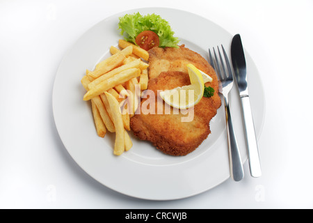 Impanati scaloppa di maiale in stile viennese con fettina di limone e patatine fritte Foto Stock