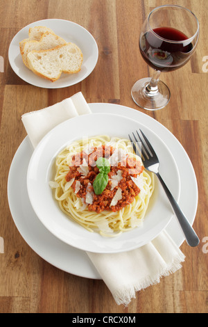 Spaghetti alla Bolognese con parmigiano e basilico, pane - ricetta file disponibile Foto Stock