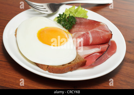 Uovo fritto su marrone con pane e prosciutto affumicato Foto Stock