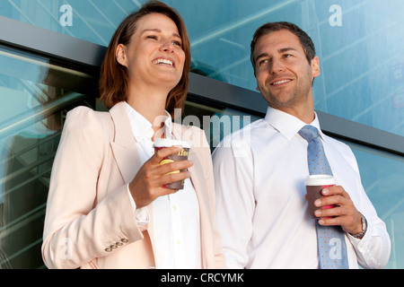 Imprenditore e imprenditrice con caffè per andare a parlare Foto Stock