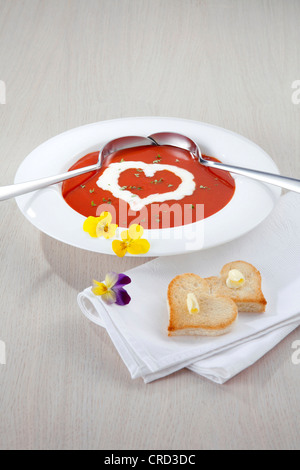 Zuppa di pomodoro con heart-shaped toast e fiori Foto Stock