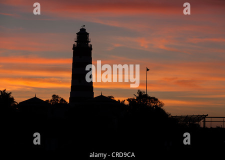 Faro Hopetown silhouette dopo il tramonto. La silhouette del famoso faro hopetown contro un luminoso rosso/arancione del cielo. Foto Stock