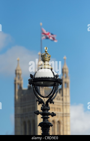 Lampada posta sul south bank con Victoria tower / Case del Parlamento contro un blu nella distanza. Londra, Inghilterra Foto Stock