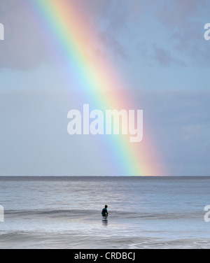 Surfer nella Baia di Hanalei sguardi alla Rainbow Foto Stock