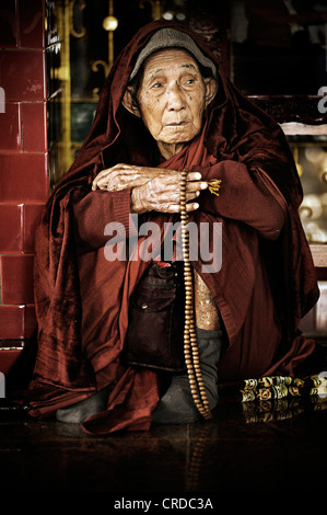 Anziani monaca buddista seduto con grani di preghiera presso la Mahamuni Pagoda di Mandalay, MYANMAR Birmania, Asia sud-orientale, Asia Foto Stock