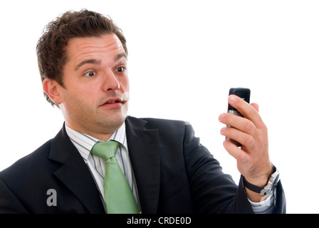 scared businessman staring at his mobile phone Foto Stock