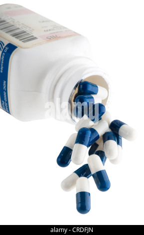 Blu e bianco capsule fuoriuscita della bottiglia di prescrizione Foto Stock