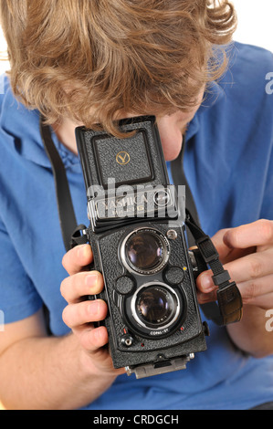 Giovane uomo scattare una fotografia con un segnale analogico di 6x6 twin-lens TLR Fotocamera Foto Stock