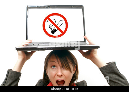 Imprenditrice con il laptop in testa, fumo simbolico off al luogo di lavoro Foto Stock