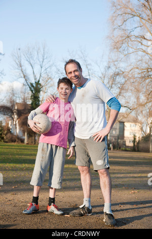 Padre e Figlio con il calcio a braccetto Foto Stock