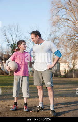 Padre e Figlio con il calcio a braccetto Foto Stock