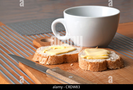 La colazione è semplice sfondo bianco con cappuccio di tè e pane e burro Foto Stock