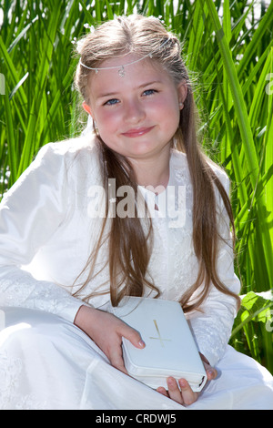 Communicant, ragazza, 9 anni, sta in piedi in erba reed Foto Stock