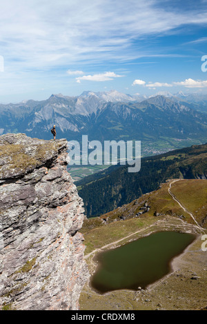 Donna in piedi su una roccia che si affaccia sul lago Baschalvasee nei cinque laghi tour su Mt Pizol, Bad Ragaz, Heidi-Country, Alpi Svizzere Foto Stock