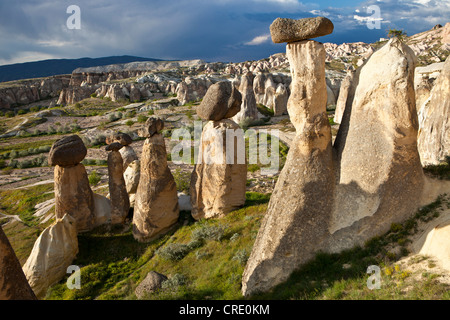 Il tufo Camini di Fata con blocchi di basalto collocato sulla parte superiore, le formazioni rocciose a Cavushin, Goreme, Patrimonio Mondiale dell UNESCO Foto Stock