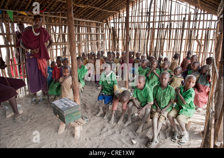 Istruzione e povertà, i bambini di una scuola primaria di classe con un insegnante, etnologia, Masai, villaggio di Kiloki, Savannah Foto Stock