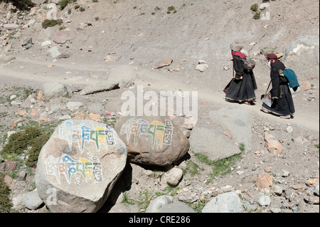 Buddismo tibetano, due pellegrini in costumi tradizionali, la scrittura sulle rocce, il percorso del pellegrinaggio attorno al Sacro Monte Foto Stock