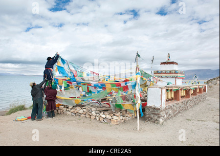 Buddismo tibetano, credenti appendere bandiere di preghiera presso lo Stupa a Seralung Gompa Monastero a lago Manasarovar, Mapham Yutsho Foto Stock