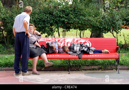 Ragazzo è dormire su una panchina nel parco Foto Stock