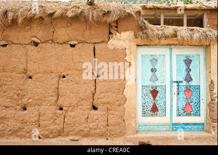 Facciata in mattoni di adobe, ornamentali tipici della porta di metallo, dipinto, Ait Bouguemez Valley, Alto Atlante, Marocco, Africa Foto Stock