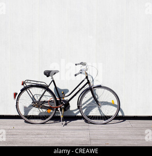 Una bicicletta appoggiata su una parete Foto Stock