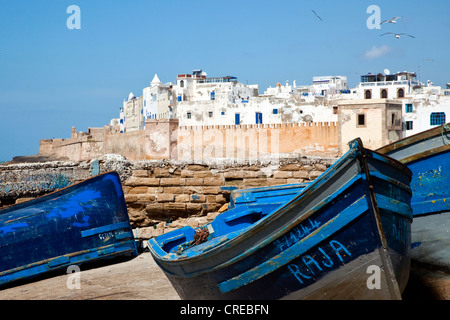 Blu barche da pesca in porto con le mura della città o bastioni sul retro, Foto Stock