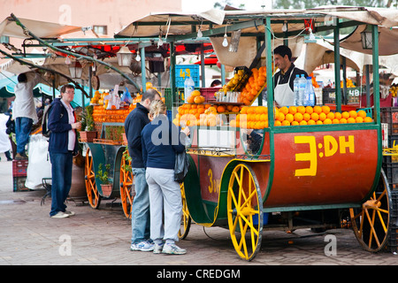 Carrozze antiche come le bancarelle del mercato per la spremuta di arancia fresca in Djemaa El Fna, medina o città vecchia Foto Stock