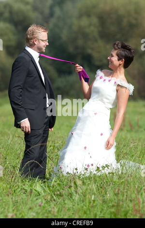 Sposa tirando il govern tie, Regensburg, Baviera, Germania, Europa Foto Stock