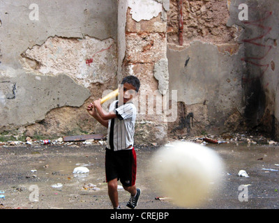 Ragazzo a giocare a baseball in un cortile nella città vecchia, Cuba, La Habana Foto Stock