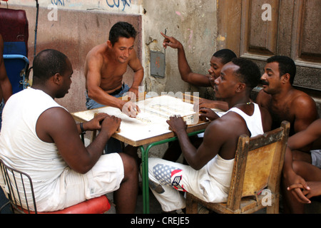 Gli uomini la riproduzione di domino su strada nella città vecchia, Cuba, La Habana Foto Stock