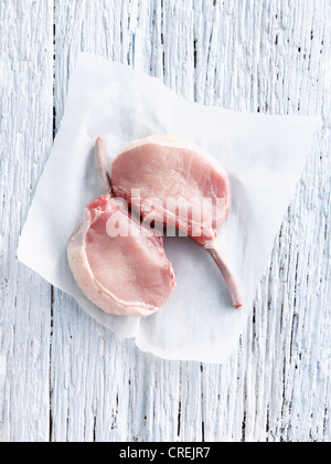 Carne di maiale cruda chop in butcher carta Foto Stock