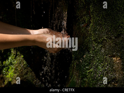 Donna di mani con acqua splash in cascata Foto Stock