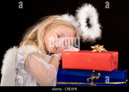 Bambina come Cristo Bambino che dorme sul presenta Foto Stock