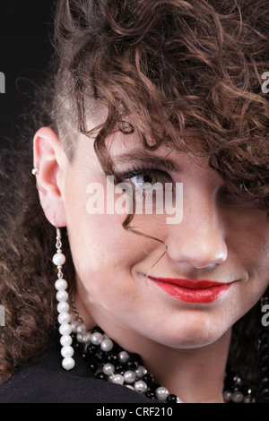 Ragazza - ear piercing super donna capelli scuri marrone naturale dai capelli sfondo nero Foto Stock