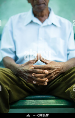 Primo piano delle mani di anziani african american uomo seduto su un banco di lavoro Foto Stock