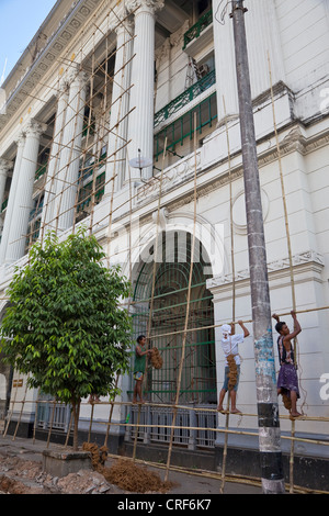 Myanmar Birmania, Yangon. Uomini al lavoro su impalcature di bambù. Foto Stock