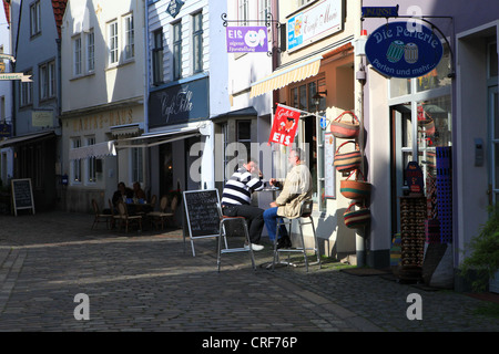 La gente del posto seduto fuori un coffee shop in storico quartiere Schnoor a Bremen, Germania Foto Stock