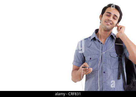 Giovane uomo sorridente ascoltando la musica con gli occhi chiusi Foto Stock
