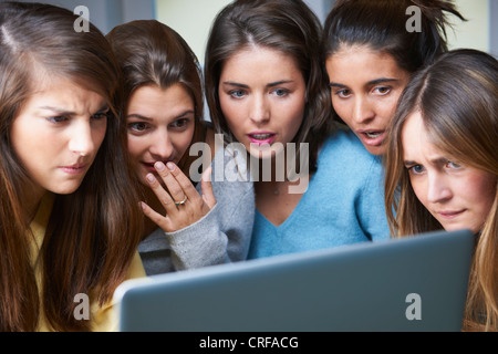 Scioccato donne utilizzando laptop insieme Foto Stock