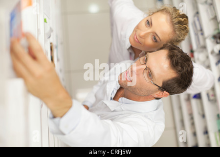 Il farmacista di prendere la medicina sul ripiano Foto Stock